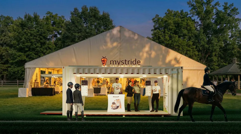 Front view of the MyStride container booth at dusk with the illuminated mystride sign and warm interior lighting