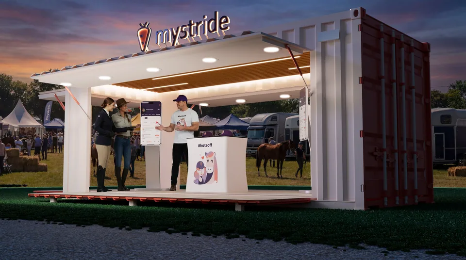 Close three-quarter dusk render of the MyStride container booth with ceiling downlights and the lit rooftop sign